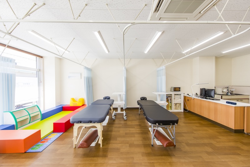 清潔感のある施術スペース全景。ゆとりある間隔で配置されたベッド。